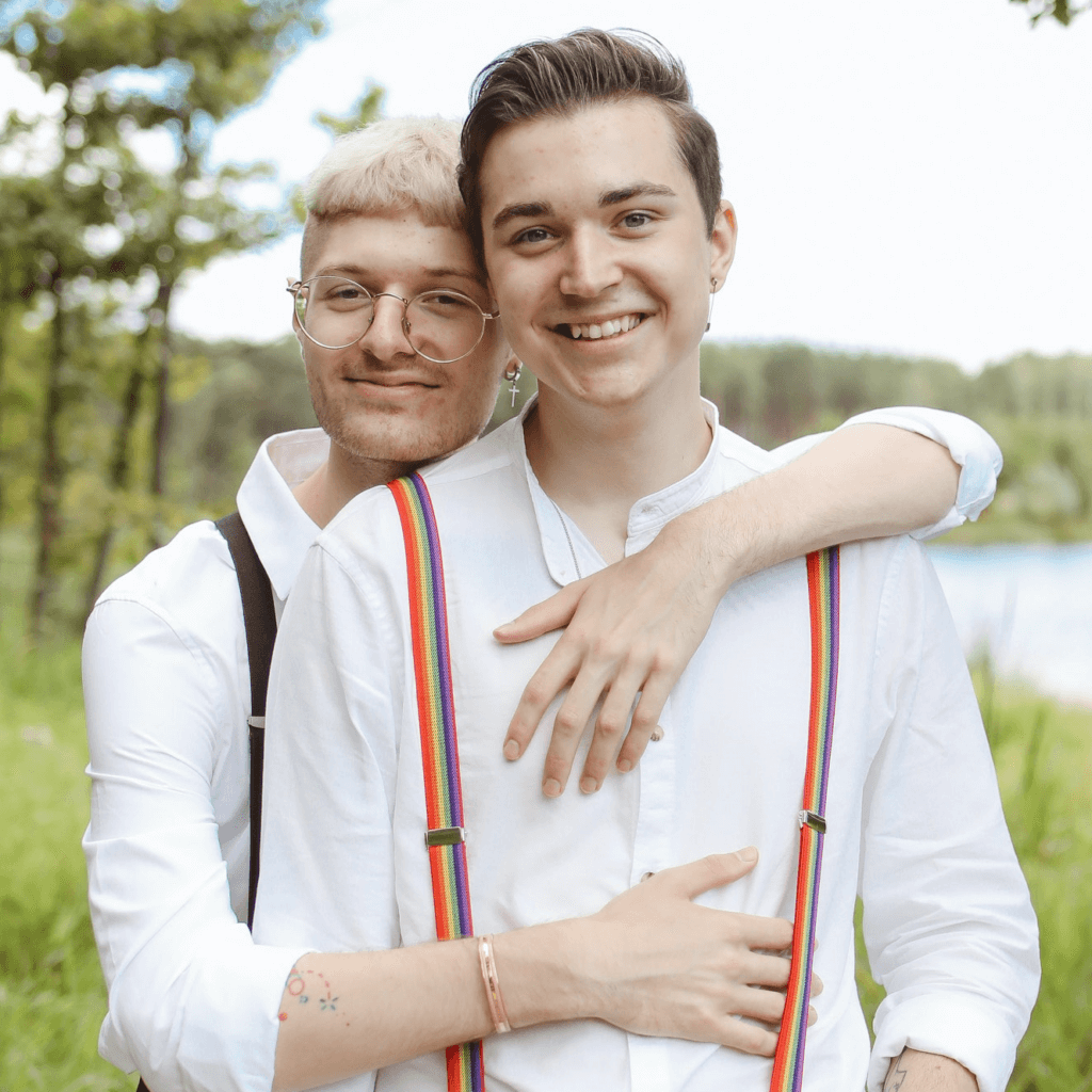 Portrait of two people embracing while smiling directly at the camera