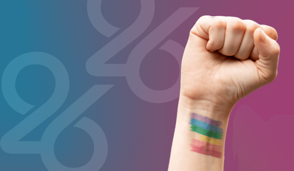 Clenched fist with purple, blue, green, yellow, orange, and red lines painted on wrist to represent pride flag