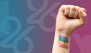 Clenched fist with purple, blue, green, yellow, orange, and red lines painted on wrist to represent pride flag