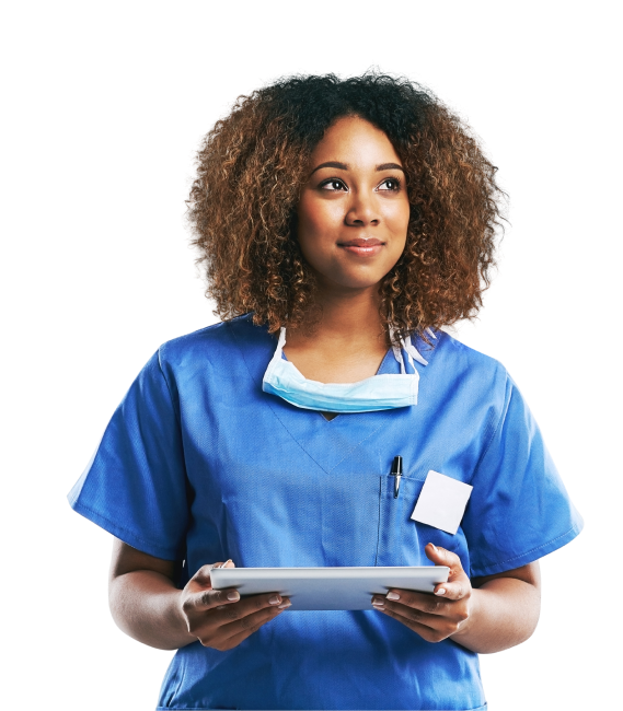 A healthcare professional in blue scrubs, with a mask around her neck and standing in central Florida, holds a tablet while looking upward with a thoughtful expression. Her curly hair frames her focused face as she considers the wellness of her patients.