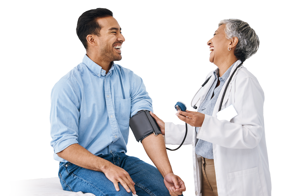 A doctor laughs while taking a seated patient's blood pressure. The patient, smiling in a light blue shirt and jeans, exudes wellness. The doctor, wearing a white coat with a stethoscope around their neck, radiates professionalism. In the background, a poster reads "FLU" in blue letters.