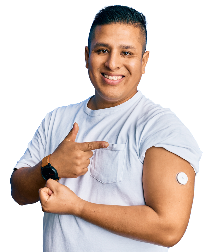 A smiling man with short hair is pointing to a small white medical device attached to his upper arm, promoting wellness. He is wearing a white t-shirt and a wristwatch, and the background is a bright blue color.