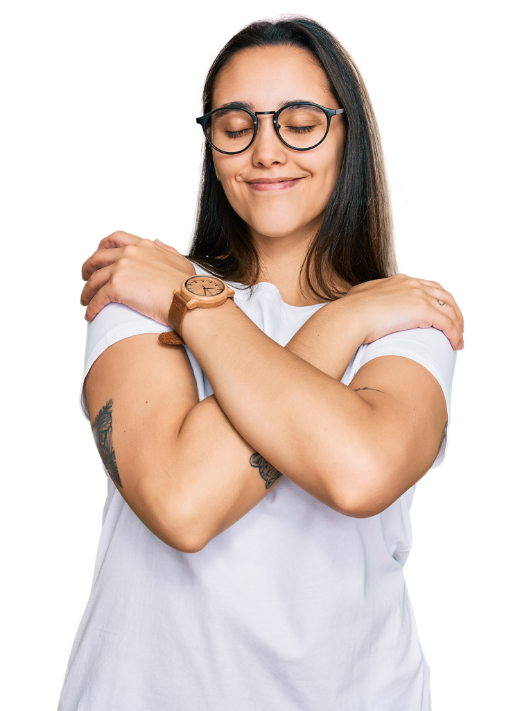 A person with long hair and glasses, wearing a white t-shirt and a wooden watch, stands against a transparent background, smiling with eyes closed and arms wrapped around themselves in a self-hugging gesture.