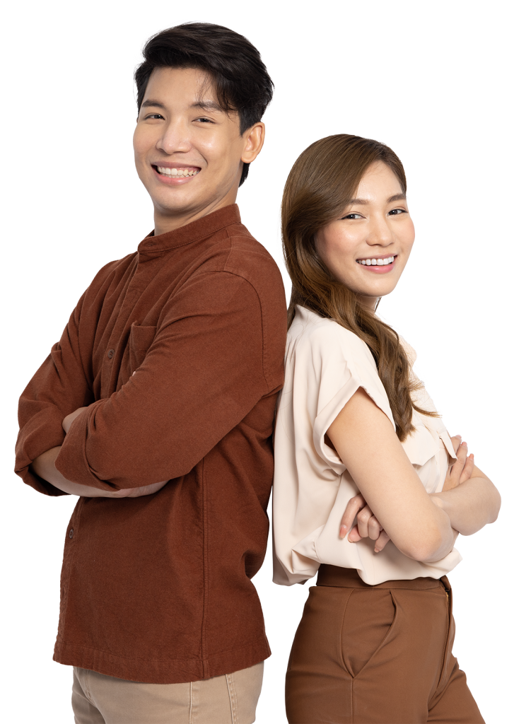 A man and a woman stand back-to-back, both smiling confidently. The man has short, dark hair and wears a brown long-sleeve shirt with beige pants. The woman has long, light brown hair and is dressed in a light-colored blouse with brown pants.