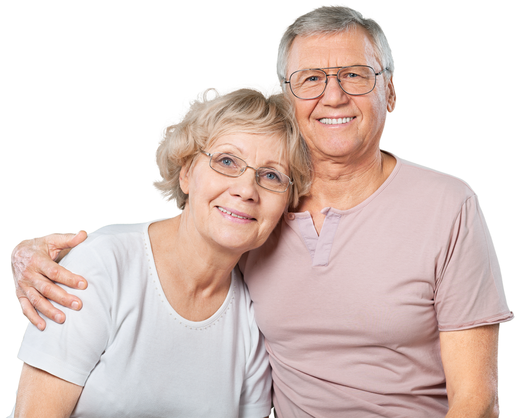 Relationship Therapy can be life changing. An elderly couple, both wearing glasses, smile warmly at the camera. The woman has short blond hair and wears a white shirt, while the man has short gray hair and wears a light pink shirt. The man has his arm around the woman.