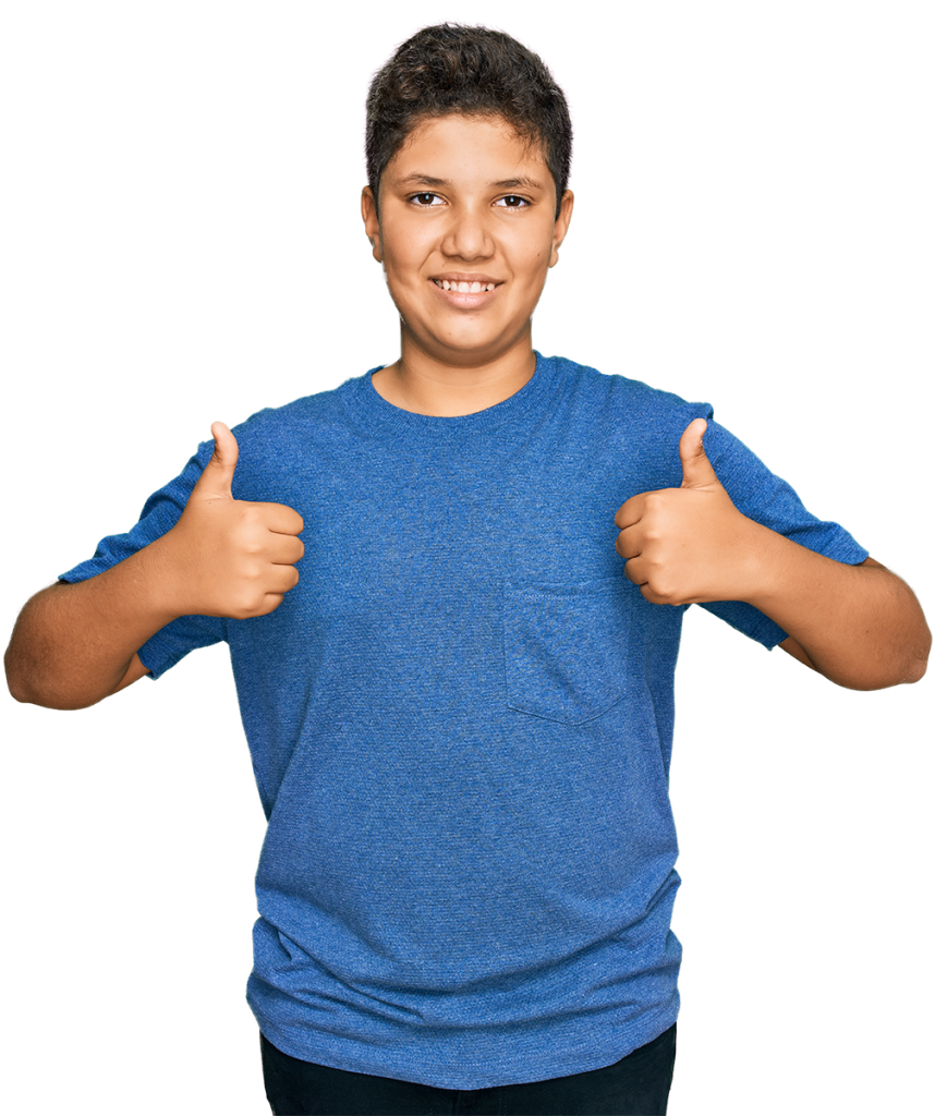 A smiling boy with short dark hair is wearing a blue t-shirt and black pants. He is giving two thumbs up with his arms raised to his sides against a solid pinkish-red background.